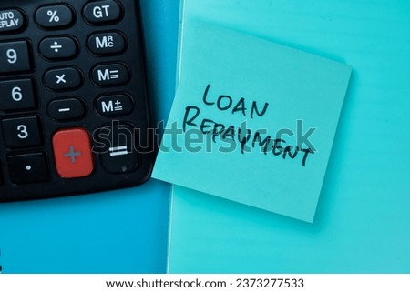 Concept of Loan Repayment write on sticky notes isolated on Wooden Table.