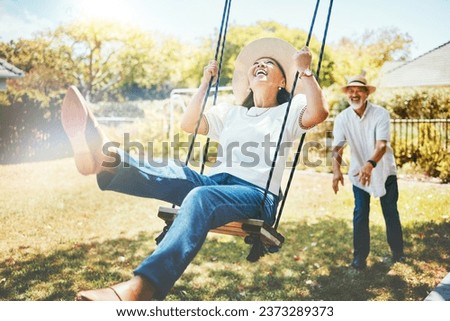 Woman, happy and fun on swing in retirement, playful and joy in summer vacation for quality time. Elderly people, support and love in relationship, funny and laugh for silly, goofy and holiday Royalty-Free Stock Photo #2373289373