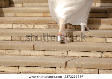 Runaway bride. Legs of a bride  on a staircase Royalty-Free Stock Photo #2373291369
