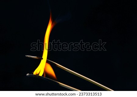 Burning match on a black background. Heat and light from fire flame