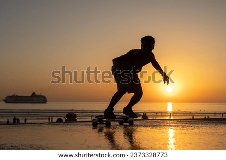 Surf skater training surfing moves near the beach at sunset. Royalty-Free Stock Photo #2373328773