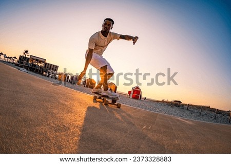 Surf skater training surfing moves near the beach at sunset. Royalty-Free Stock Photo #2373328883