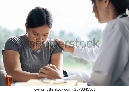doctor therapist wearing white uniform with stethoscope touching frustrated patient shoulder