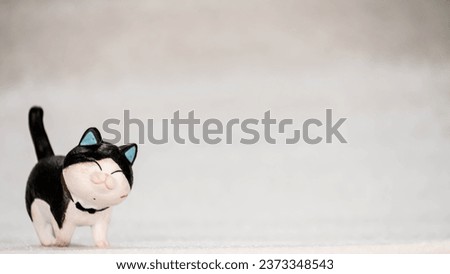 Black and white cat animal action figure walking on a blurred white background