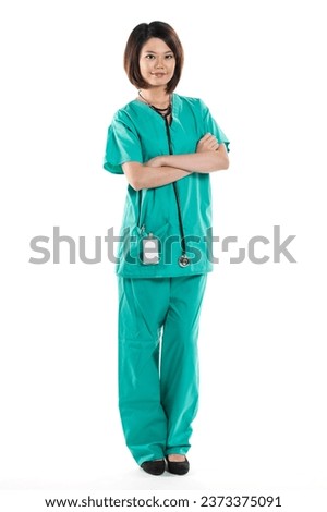 Chinese woman doctor wearing a green Scrubs and stethoscope. Isolated on white. Full length Portrait. Royalty-Free Stock Photo #2373375091