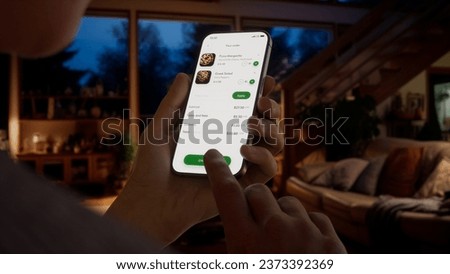 CU Caucasian man using food delivery application to make an order. Fictional app Royalty-Free Stock Photo #2373392369