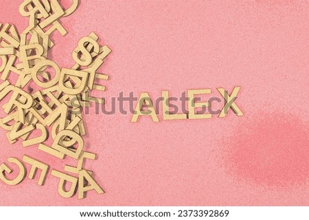 Popular and modern baby boy fashion name ALEX in wooden English language capital letters spilling from a pile of letters on a red background pencil sketch