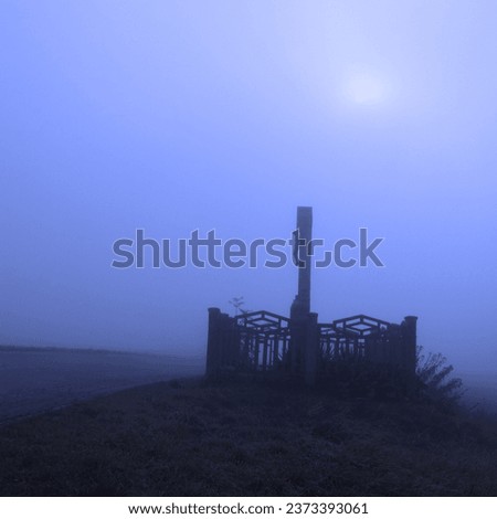 Misty landscape, cross by the road, morning sun in fog, autumn atmosphere, cold weather, blue photo