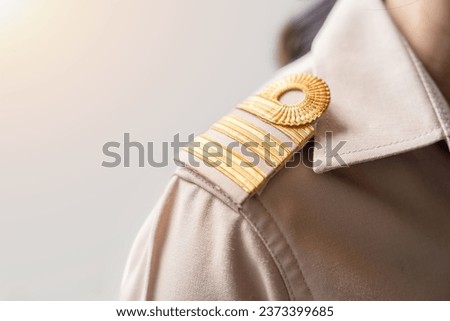 Photo of a brown uniform with a gold stripe on the shoulder, Thai civil servant uniform. Royalty-Free Stock Photo #2373399685