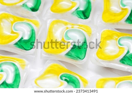 Dishwasher pods background. Yellow and green washing gel. Laundry ball texture. Cleaning capsules. Laundry background. Washing dishes pattern.