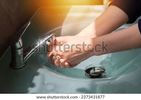 Wash your hands using hand sanitizer to kill germs that you might accidentally touch, such as the COVID-19 virus, before working or eating or doing other activities. Royalty-Free Stock Photo #2373431877