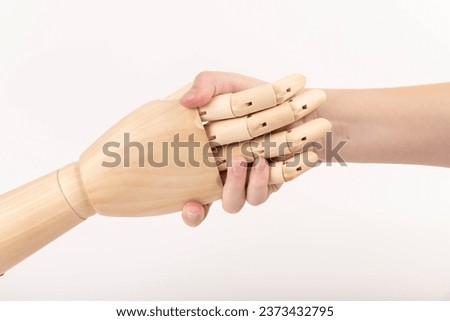 Close up of the hand of wooden mannequin hand shaking human hand. Hands concept. Hope. Help. Concept. 