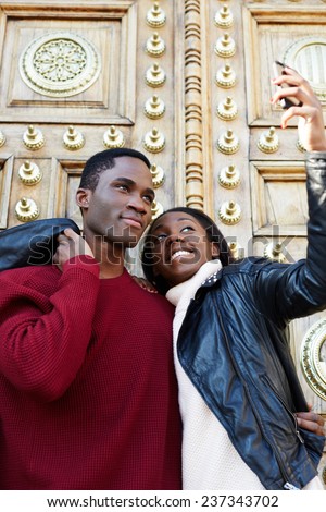 Dating couple happy in love taking self-portrait photo on beautiful antique door background, happy friends taking self portrait outdoors, tourist man and woman making self portrait with mobile phone