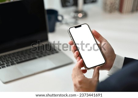 Close up businessman hand holding smartphone with blank screen for apps advertising.