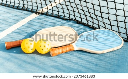Two pickleball rackets and two balls lying on the floor of a sports court. Pickle ball concept. Sports with rackets. Sports similar to tennis and paddle tennis. Royalty-Free Stock Photo #2373461883