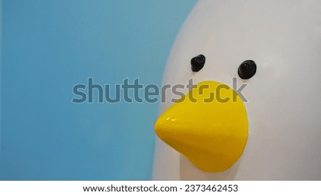 Close-up photo of a duckling statue on a blue background. Picture for use in illustrations Background image or copy space