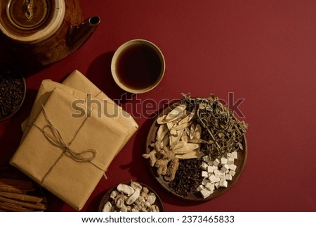 A bowl filled with tonic arranged with an earthen pot, packs of medicine and some wooden dishes containing several types of traditional Chinese medicine. Copy space. Blank space for mockup Royalty-Free Stock Photo #2373465833