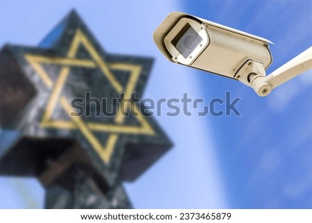 Security camera with star of David on background. Concept of monitoring religious buildings of the Jewish faith Royalty-Free Stock Photo #2373465879