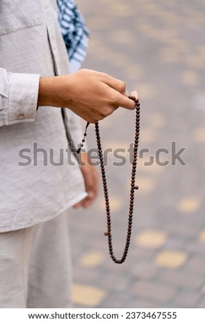 Male hands of an Islamic man holding a rosary during prayer of conversion and worship of Allah