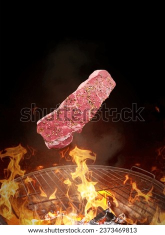 fresh steak meat falling on the fire grill-photo levitation concept-creative idea-black background