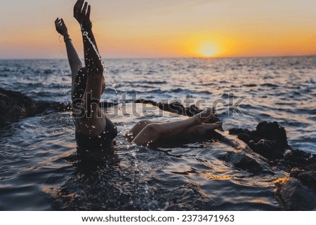 Young cheerful relaxed woman  in a natural sea bath on the seashore. Thalassotherapy and wellness 