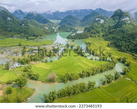Aerial landscape in Quay Son river, Trung Khanh, Cao Bang, Vietnam with nature, green rice fields and rustic indigenous houses. Travel and landscape concept. Royalty-Free Stock Photo #2373485193
