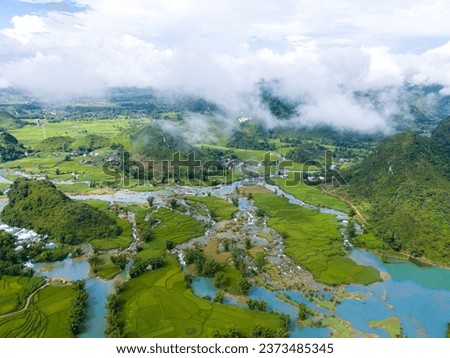Aerial landscape in Quay Son river, Trung Khanh, Cao Bang, Vietnam with nature, green rice fields and rustic indigenous houses. Travel and landscape concept. Royalty-Free Stock Photo #2373485345