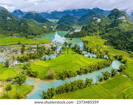Aerial landscape in Quay Son river, Trung Khanh, Cao Bang, Vietnam with nature, green rice fields and rustic indigenous houses. Travel and landscape concept. Royalty-Free Stock Photo #2373485359