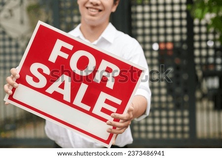 Big for sale sign in hands of real estate agent