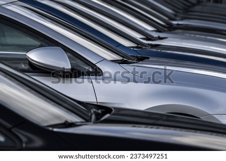 A closeup shot of a row of silver and blue cars with their side views on the picture