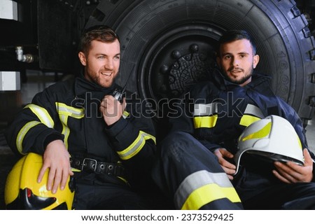Portrait of two heroic fireman in protective suit and helmet