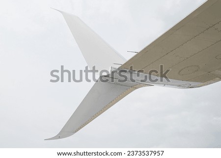 Split scimitar winglets with the lower part angled downwards to reduce the aircraft's drag by partially recovering the energy generated by the wing tip vortex even further than normal winglets.  Royalty-Free Stock Photo #2373537957