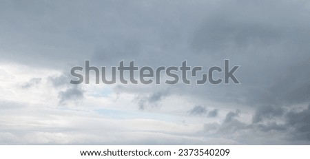Autumn brings overcast skies adorned with gray stratus clouds, hinting at impending rain. This full-screen view provides ample space for text or design elements, making it perfect for various projects Royalty-Free Stock Photo #2373540209