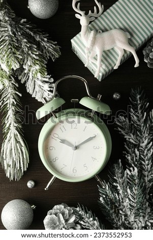 A clock with a New Year's decoration, on a dark background.