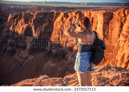 The girl admires the view at the Horseshoe Bend tourist attraction in Arizona.