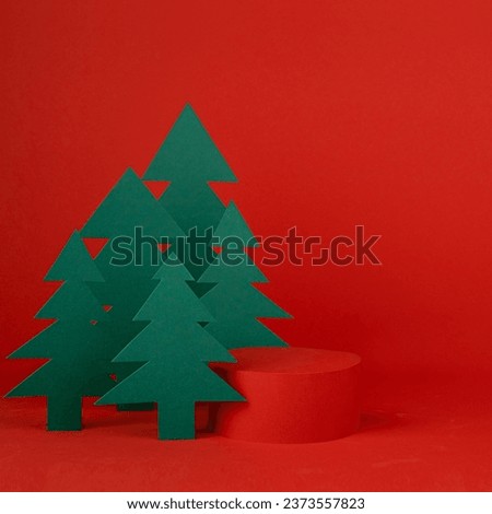 Christmas art one cylinder podium and red stage for presentation gifts, cosmetic products, goods, green paper spruces in cartoon style, copy space, square. New year template for advertising, design.