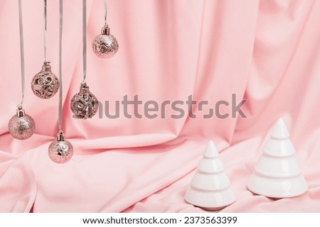 Festive Christmas background, Christmas card. Christmas garland and two white artificial fir trees on a pink background. Pink Christmas.