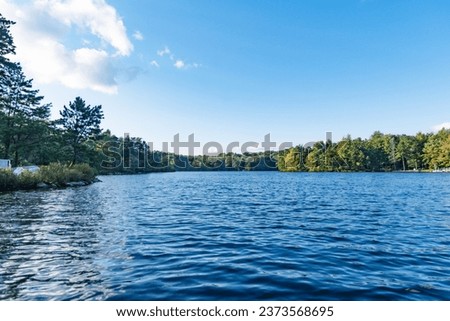 Outdoors lake background from a kayak on top of water surface, perfect fall day, copy space image horizontal.