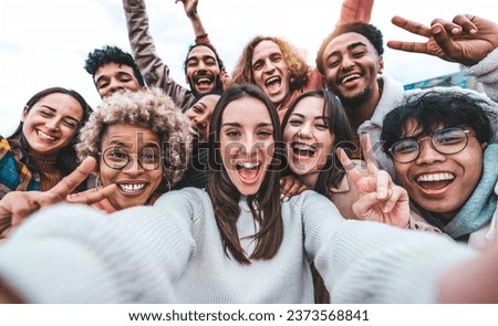 Multicultural young people smiling together at camera outside - Happy friends taking selfie pic with smart mobile phone device - College students having fun - Youth community concept