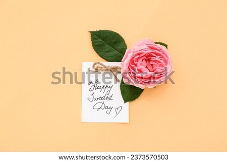 Greeting card with text HAPPY SWEETEST DAY and rose flower on beige background. National Sweetest Day Royalty-Free Stock Photo #2373570503