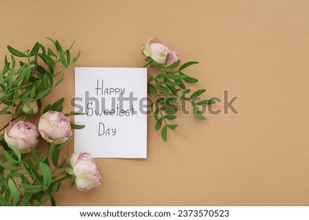 Greeting card with text HAPPY SWEETEST DAY and rose flowers on brown background. National Sweetest Day Royalty-Free Stock Photo #2373570523