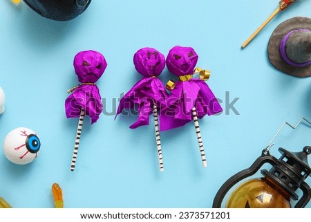 Sweet lollipops with jelly eye and witch hat for Halloween party on blue background