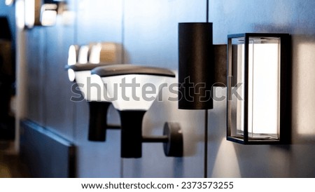 Sample of exterior LED wall lamp in home design store. Modern light fixture mounted on wall for outdoor lighting Royalty-Free Stock Photo #2373573255