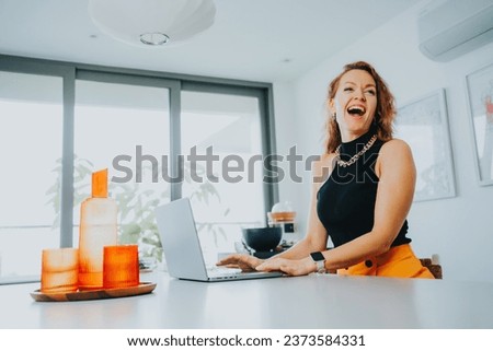 Businesswoman working on laptop computer sitting at home and managing her business via home office