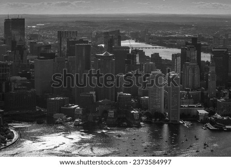 An aerial view of the Boston skyline with tall buildings and the Charles river in the background.