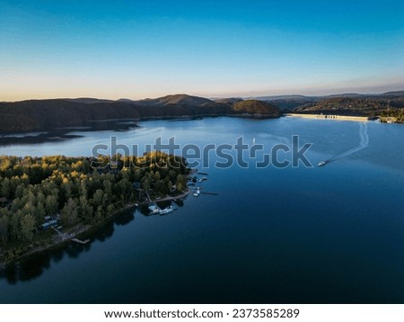 Sunset over Lake Solina in the Bieszczady Mountains, bird's eye view of the dam and the ship in autumn