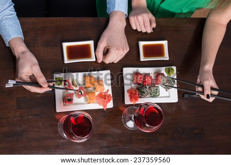 Young couple are eating sushi at restaurant. Top view.