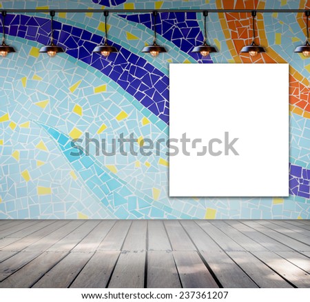 Blank white paper frame hanging on mosaic tile wall with ceiling lamp for write information message