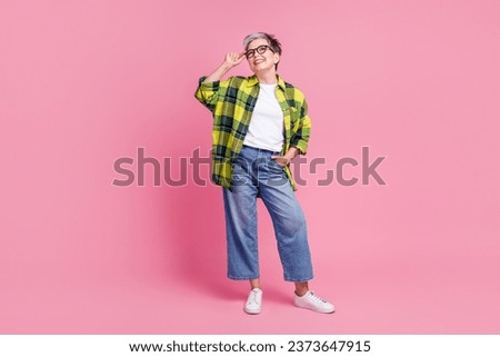 Full size photo of positive person with gray hair dressed plaid shirt look empty space touch glasses isolated on pink color background