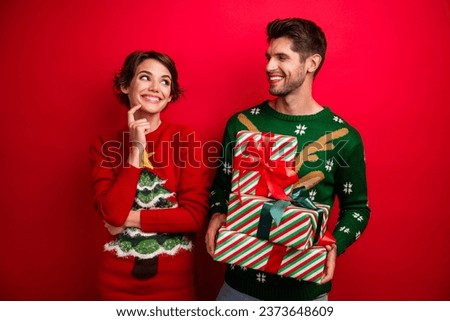 Portrait of two creative cheerful people hold pile stack box package look each other isolated on red color background